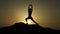 Silhouette of young woman enjoying harmony with nature while practicing yoga