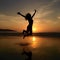 Silhouette of young woman jumping on the beach at sunset.