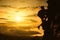 Silhouette of young woman lead climbing high.