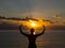 Silhouette young woman practicing yoga on the beach at sunset. Healthy live and active rest concept.