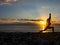 Silhouette young woman practicing yoga on the beach at sunset. Healthy live and active rest concept.