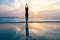 Silhouette young woman practicing yoga on swimming pool