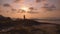 Silhouette of young woman relaxing and enjoy beauty sunset on the ocean coast. Girl doing yoga on the beach. Person