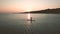 Silhouette of young woman on stand up paddle board. Aerial view at sunset