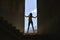 Silhouette of a young woman standing in the window opening destroyed an abandoned building