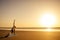 Silhouette of young woman in a stylish suit for yogi jumpsuit doing yoga on the beach in pose copy space