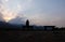 Silhouette of young woman watching warm setting sun.