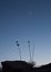 Silhouette of yucca plant and sandstone rock with crescent moon and a few stars at dusk