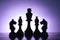 Silhouetted chess pieces against a purple gradient background