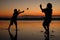 Silhouetted Children Playing on the Beach