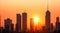 Silhouetted city skyline with skyscrapers against a warm, urban sunset