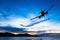 Silhouetted commercial airplane flying at sunset