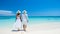 Silhouetted couple enjoying sunny summer day at beach with sparkling blue ocean waves