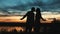A silhouetted couple takes and evening walk
