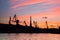 Silhouetted cranes at shipyard,