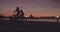 Silhouetted cyclists riding along the seaside promenade at sunset