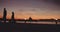 Silhouetted cyclists riding along the seaside promenade at sunset