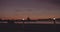 Silhouetted cyclists riding along the seaside promenade at sunset