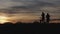 Silhouetted Cyclists at Sunset on Mountain Trail