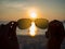 Silhouetted of eye glasses with hands holding, with sunset at beach view