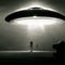 a silhouetted figure like a bright glowing UFO flying over the sky illustration