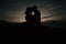 Silhouetted figures embracing in a romantic kiss against a beautiful sun-kissed dusky sky