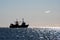 Silhouetted fishing boat and seagulls in a shining sea