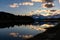 Silhouetted forest with cloudy sky reflecting on Snake river