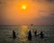 Silhouetted group of boy are playing a ball in the sea