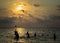 Silhouetted group of boy are playing a ball in the sea