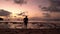 Silhouetted guy on the beach during sunset. Sunset in the tropics. The guy joyfully runs out of the water