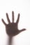 Silhouetted hand on frosted glass.