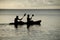 Silhouetted kayakers on the ocean