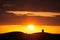 Silhouetted lamb on a hilltop at sunset