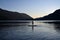 Silhouetted male paddleboarder on Lake Crescent in Olympic National Park.