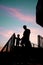 Silhouetted man and child walking down stairs in sunset