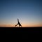 Silhouetted man doing a cartwheel at sunset