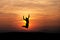 Silhouetted man jumping in sunset