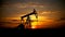 Silhouetted oil pump in operation drilling oil against a picturesque sunset backdrop