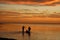 Silhouetted People Walking in the Lagoon at a Colorful Sunset