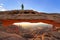 Silhouetted person standing on top of Mesa Arch, Canyonlands Nat