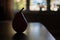 Silhouetted Red Pear on Wood Table