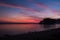 Silhouetted reflecting rock on sunset sand beach