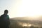 Silhouetted Solitude: Dusty Sunset View with Man Facing Away