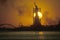 Silhouetted Statue of Liberty with scaffolding at sunset, New York City, New York