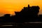 Silhouetted of Tanah Lot and sea waves in twilight, Bali, Indonesia.