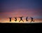 Silhouetted teens jumping in sunset