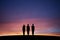 Silhouetted three teenagers standing straight in sunset