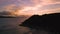 Silhouetted Trees And Mountain By The Beach During Sunset - aerial ascend