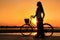 Silhouetted woman with bicycle at Mekong river